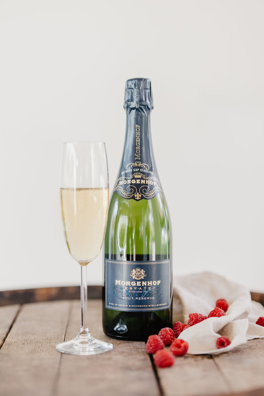 Morgenhof Estate Brut Reserve Methode Cap Classique with a flute of sparkling wine and fresh raspberries