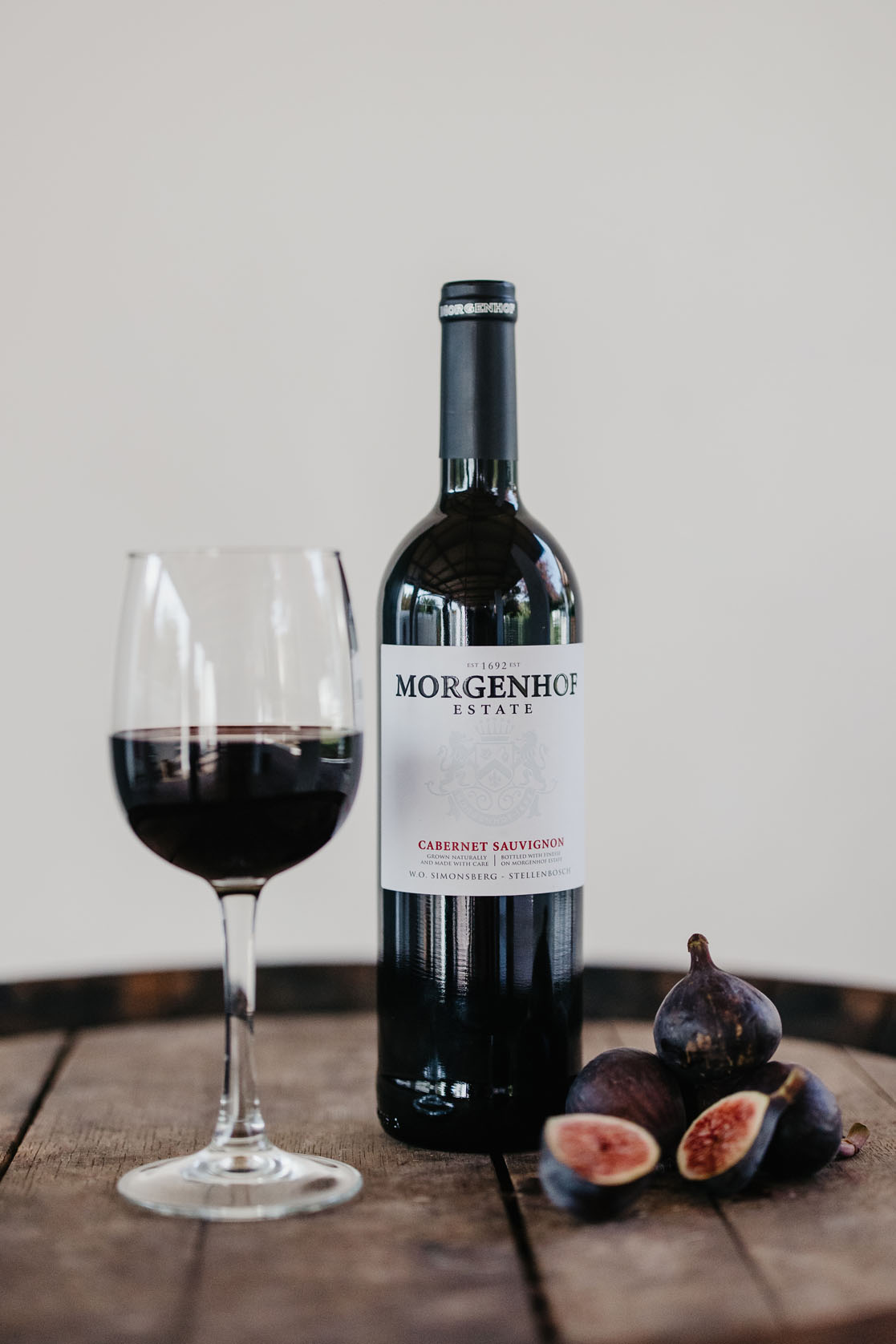 Morgenhof Estate Cabernet Sauvignon bottle and a glass of red wine with fresh figs