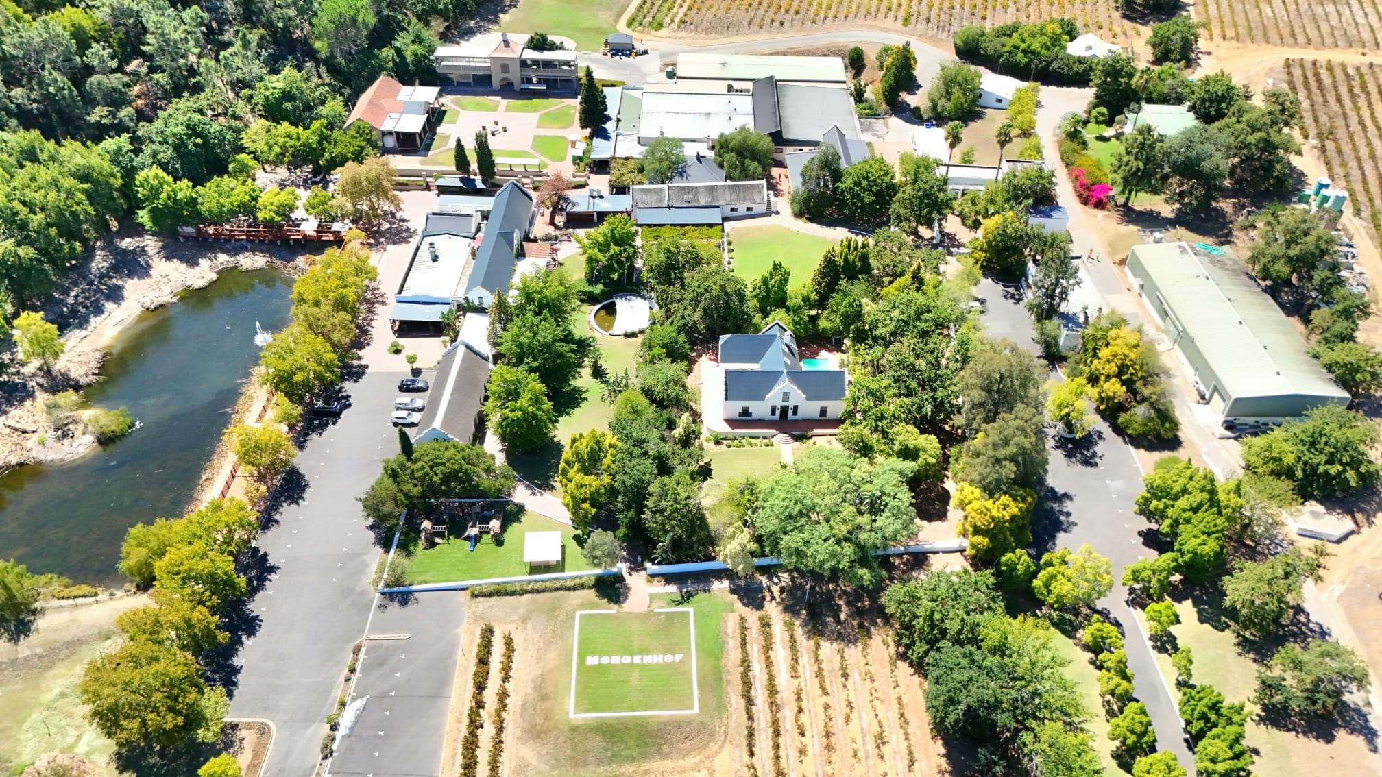 Aerial view of the Cape Dutch manor house and gardens at Morgenhof Wine Estate, surrounded by vineyards